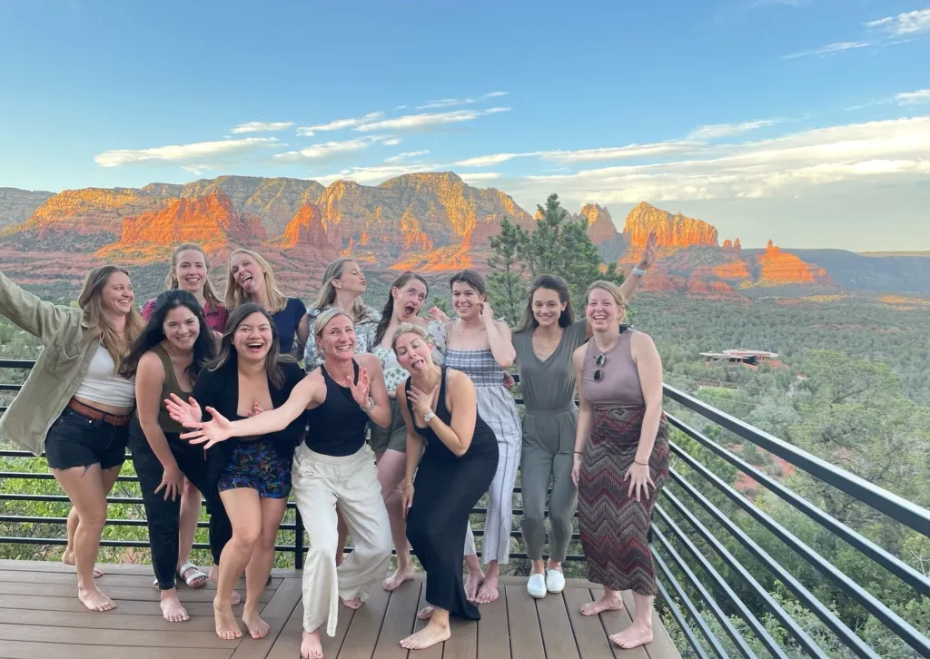Joyful group of women at a Sedona retreat with red rocks in the background